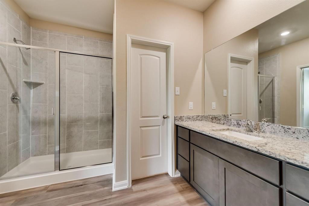 304 Wandering Stream Way Princeton, TX 75407 - Photo 6 of 13 a bathroom with a granite countertop sink mirror and shower