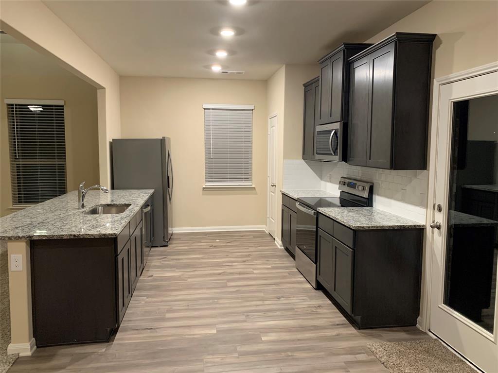 304 Wandering Stream Way Princeton, TX 75407 - Photo 8 of 13 a kitchen with stainless steel appliances granite countertop a stove and a refrigerator