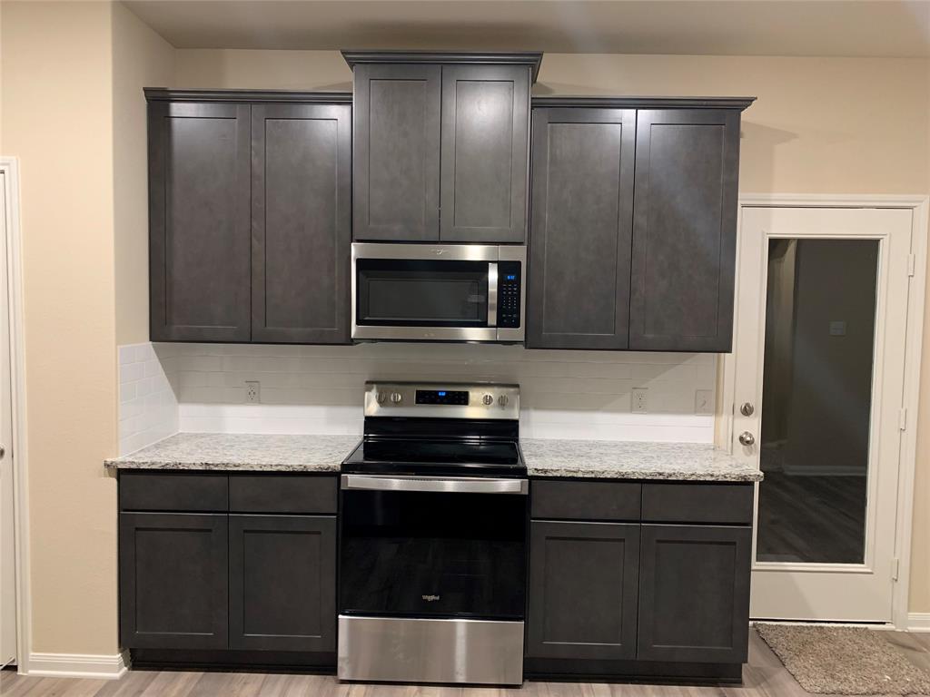 304 Wandering Stream Way Princeton, TX 75407 - Photo 9 of 13 a kitchen with a refrigerator and a stove top oven