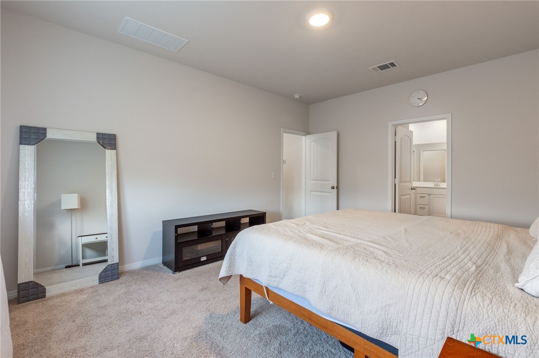 205 Charles Trail Georgetown, TX 78626 - Photo 23 of 38 a bedroom with a bed and a cabinets