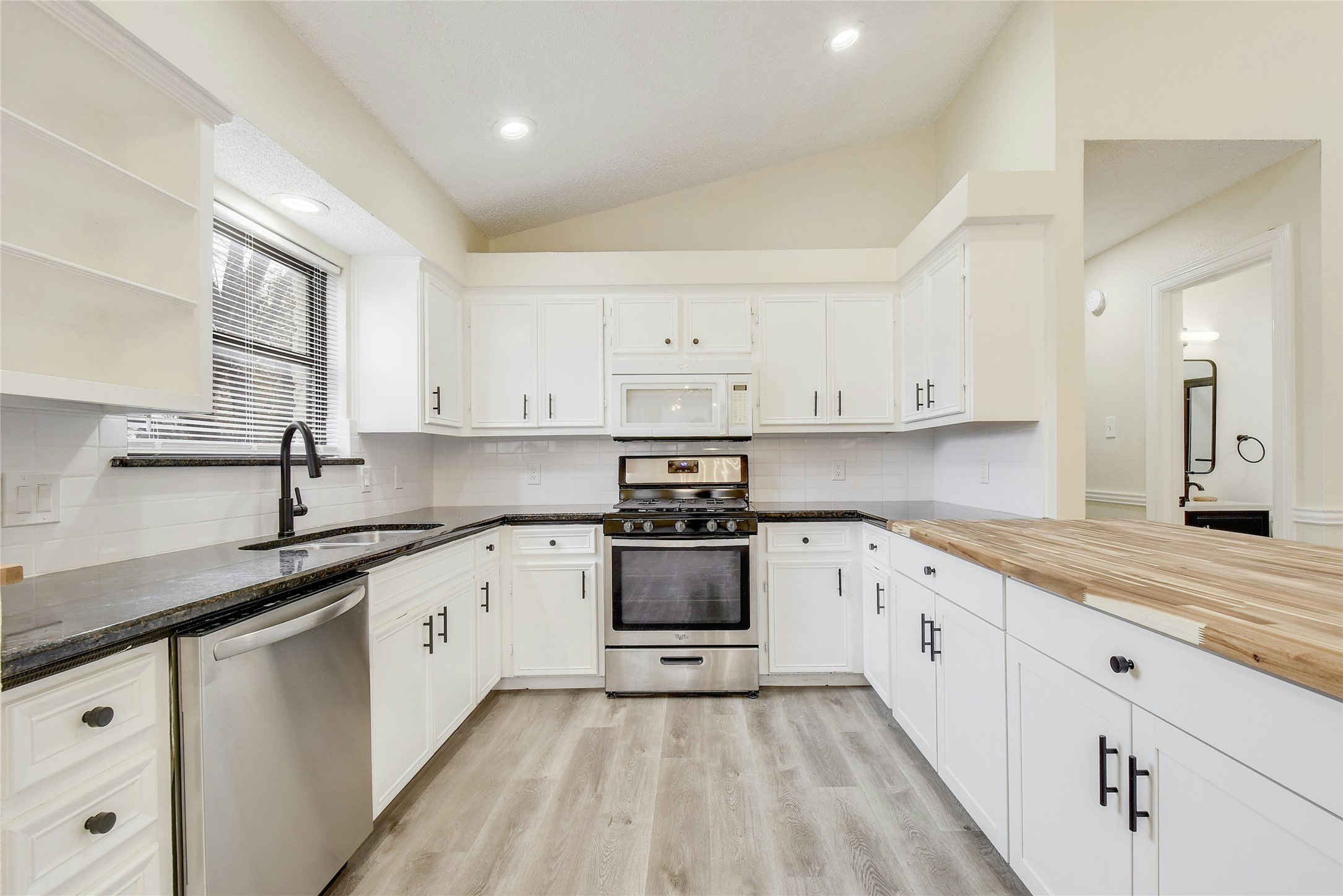 5610 Meadow Crest Austin, TX 78744 - Photo 6 of 25 a kitchen with granite countertop white cabinets and white appliances