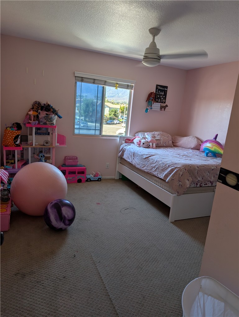 7397 McClellan Court Fontana, CA 92336 - Photo 13 of 14 a bedroom with a bed and a chandelier