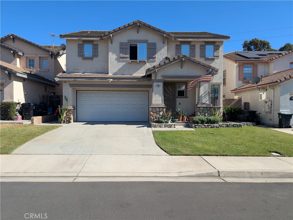 7397 McClellan Court Fontana, CA 92336 - Photo 2 of 14 a front view of a house with a yard and garage