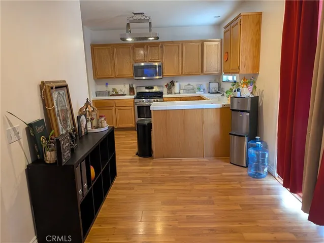 a kitchen with a sink wooden cabinets and stainless steel appliances