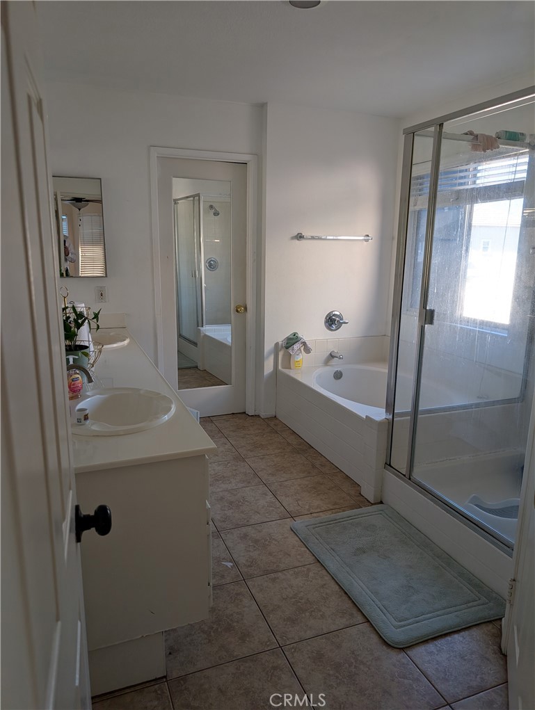 7397 McClellan Court Fontana, CA 92336 - Photo 10 of 14 a bathroom with a tub shower and mirror