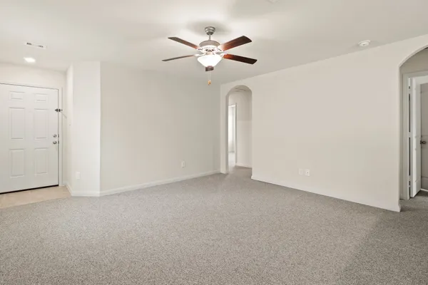 an empty room with closet and ceiling fan