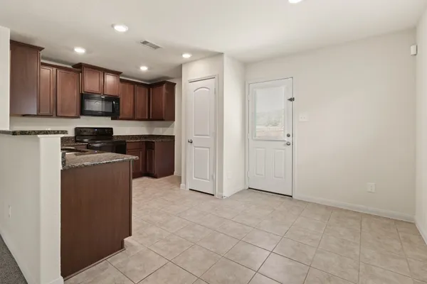 a kitchen with kitchen island granite countertop white cabinets and stainless steel appliances
