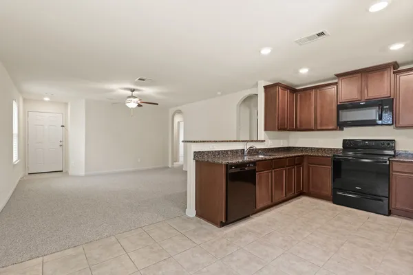 a kitchen with stainless steel appliances granite countertop a refrigerator and a stove top oven