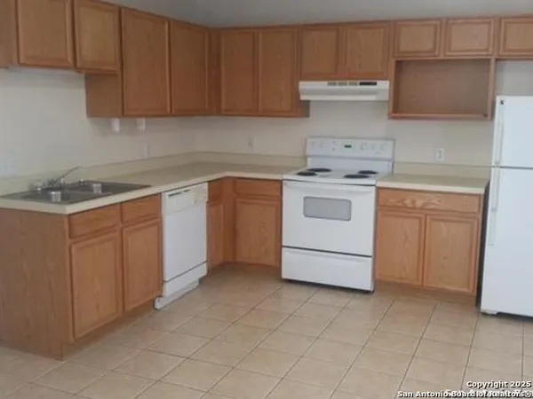 a kitchen with a stove top oven sink and cabinets