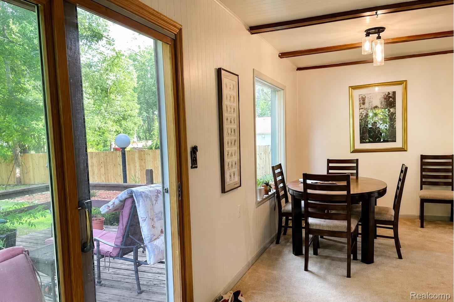 9552 Wayne Road Livonia, MI 48150 - Photo 10 of 31 The adjoining dining nook continues the home’s warm retro character with clean finishes, wood accents, and a bright view out to the deck and backyard. This inviting space feels beautifully maintained and full of charm, offering a cozy spot for meals, morning coffee, or casual entertaining.