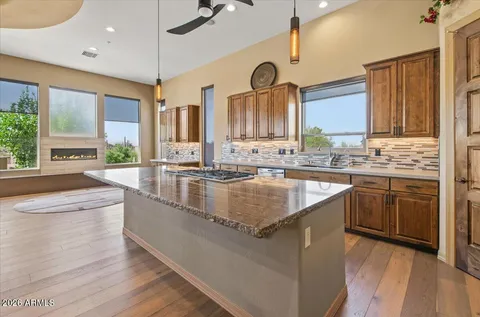 an entryway with a dining table wooden floor and a view of kitchen
