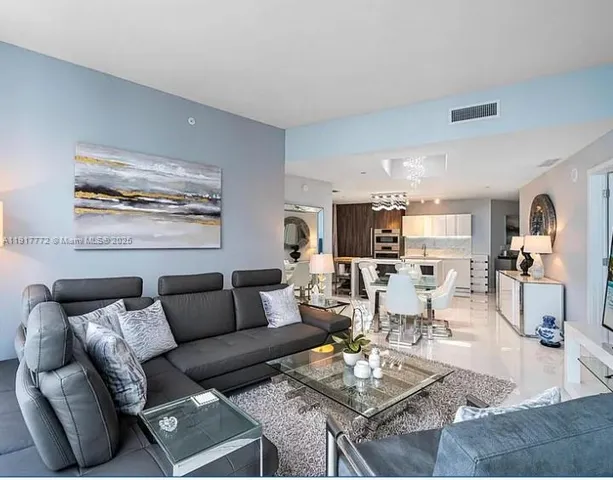 a living room with furniture kitchen view and a table