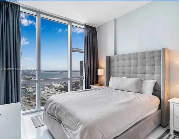 a bedroom with a large bed and a potted plant
