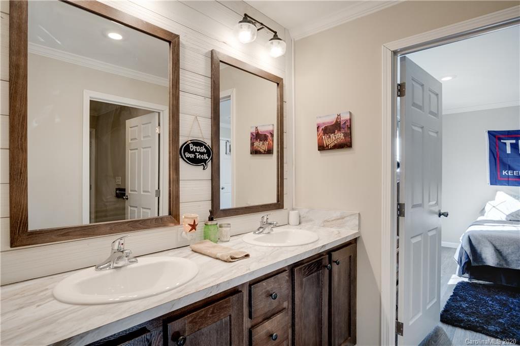 824 Dillsboro Road Sylva, NC 28779 - Photo 24 of 39 a en suite bathroom with a granite countertop sink and a mirror