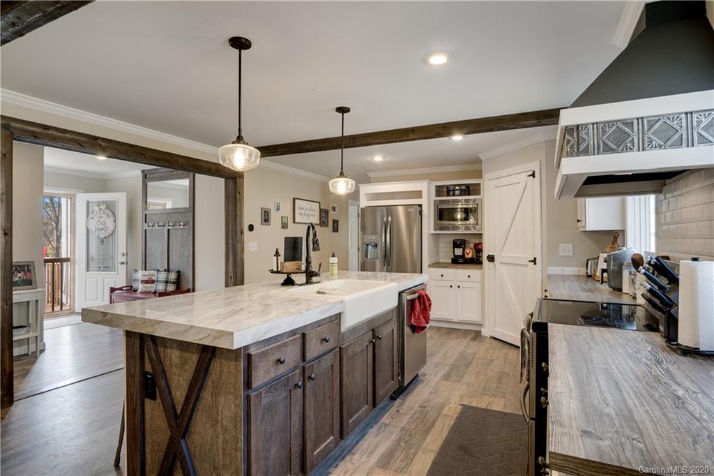 824 Dillsboro Road Sylva, NC 28779 - Photo 9 of 39 a dining hall with stainless steel appliances kitchen island granite countertop a table chairs and a wooden floor