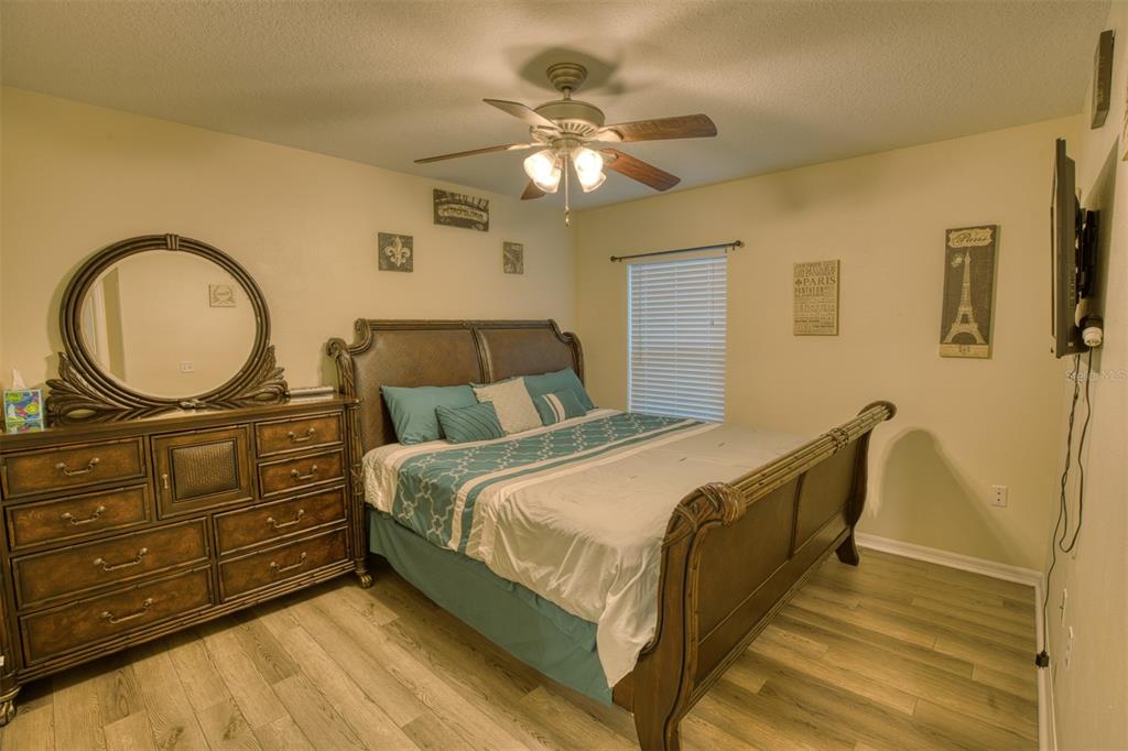 4303 Orange Ridge Court Valrico, FL 33596 - Photo 11 of 40 a bedroom with a bed and a chandelier