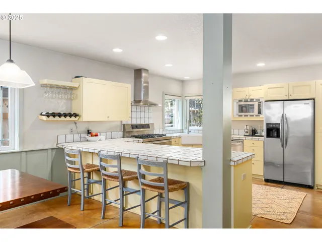a kitchen with kitchen island a counter top space cabinets and stainless steel appliances