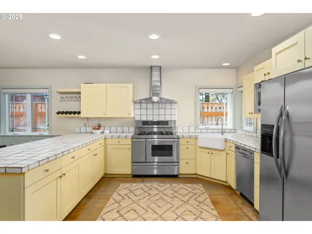 a kitchen with stainless steel appliances granite countertop a stove a sink and a refrigerator