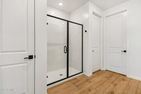 a spacious bathroom with a double vanity sink a mirror and a shower