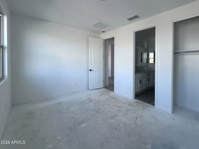 an empty room with closet and windows