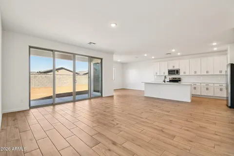 a view of kitchen with kitchen island a sink wooden floor and a refrigerator