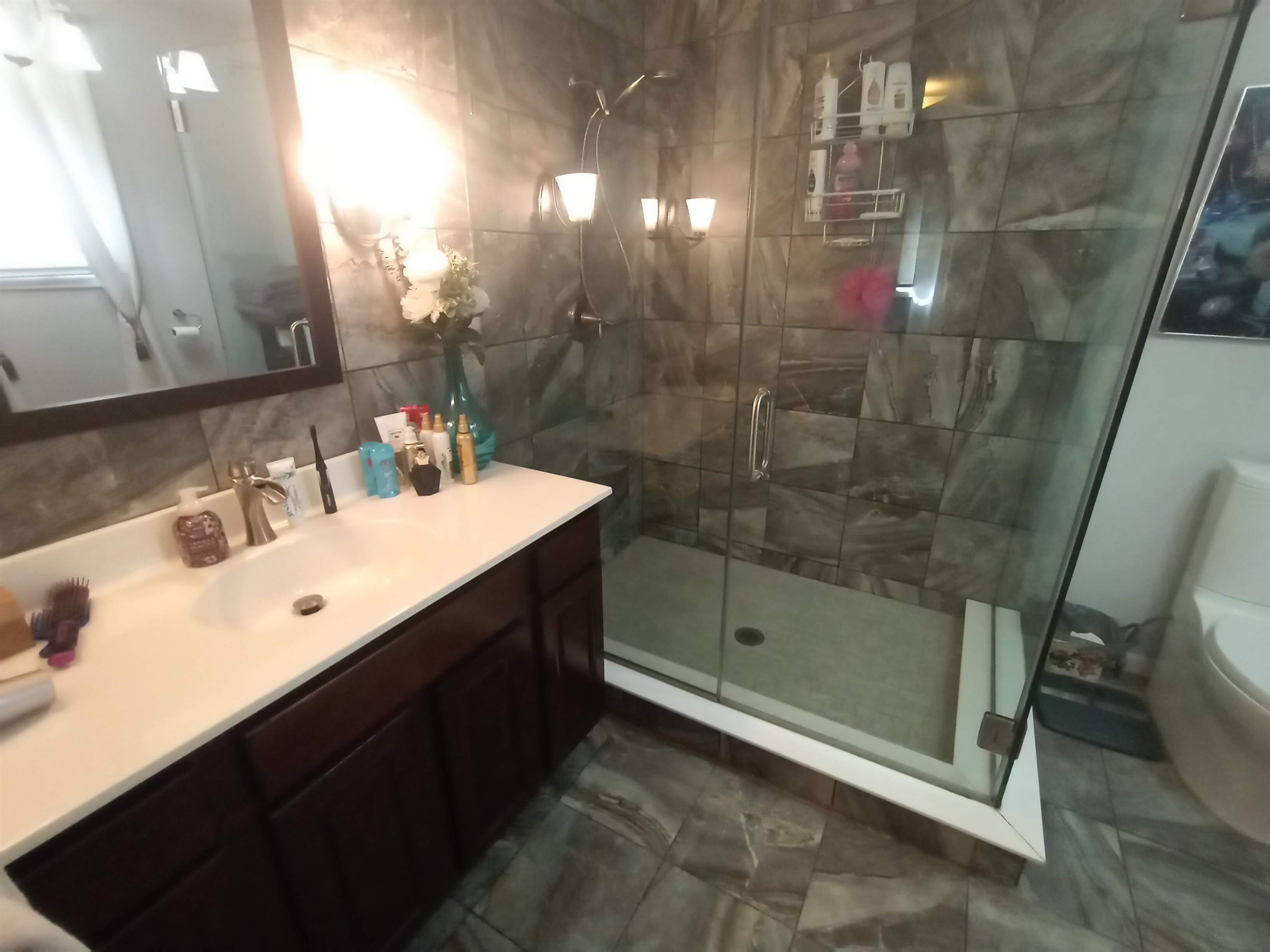 5242 Brookview Road Rockford, IL 61107 - Photo 23 of 44 a bathroom with a sink a mirror and a glass door shower