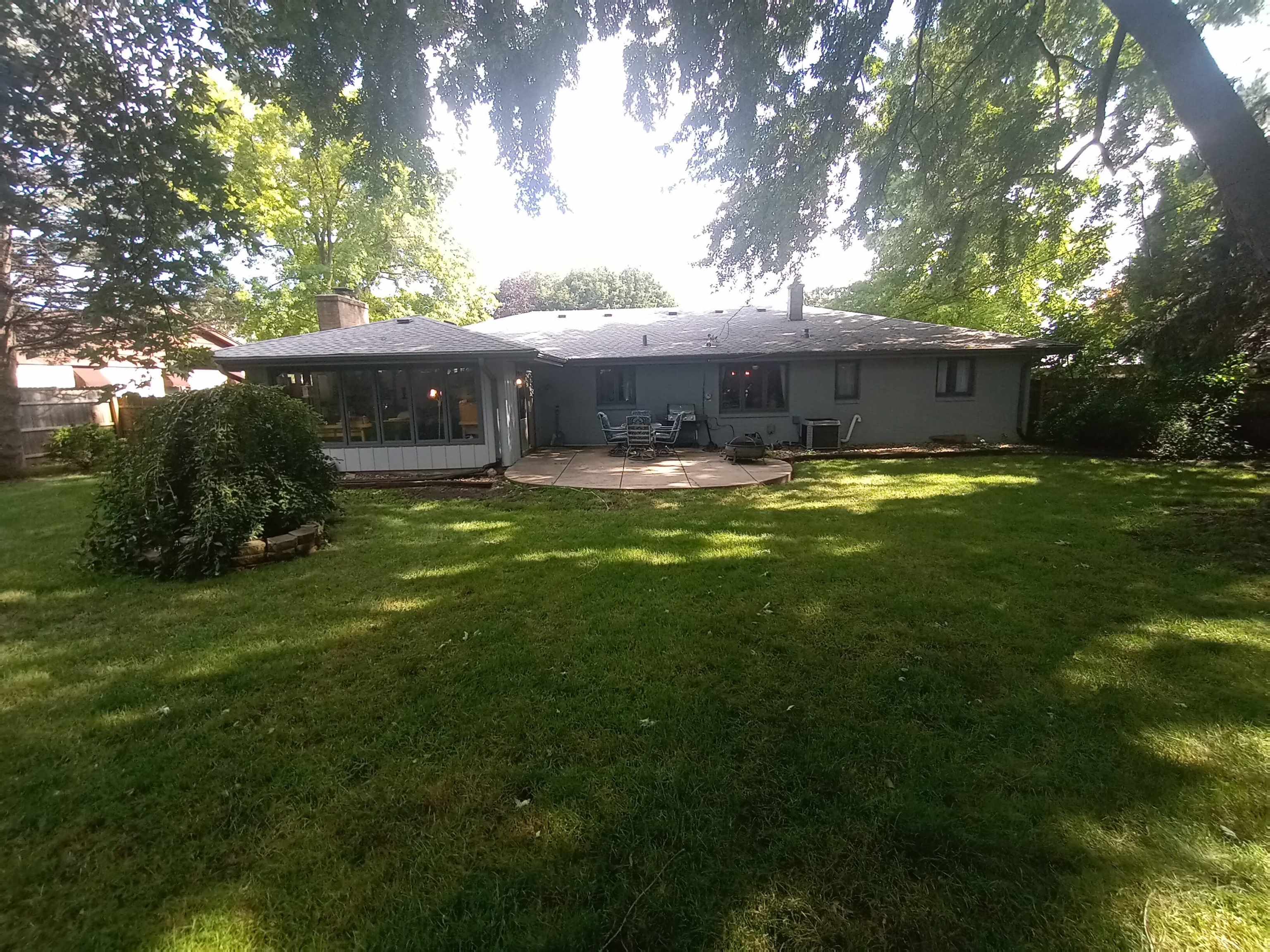 5242 Brookview Road Rockford, IL 61107 - Photo 41 of 44 a view of a backyard with table and chairs potted plants and large tree