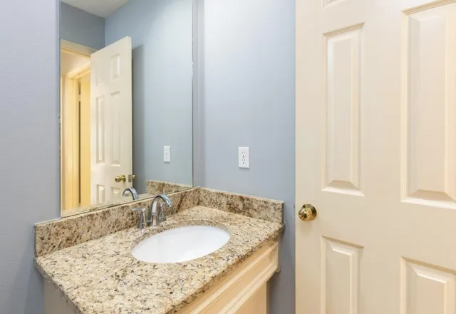 a bathroom with a granite countertop sink and a mirror