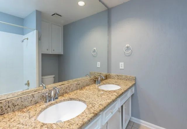 a bathroom with a granite countertop sink and a mirror