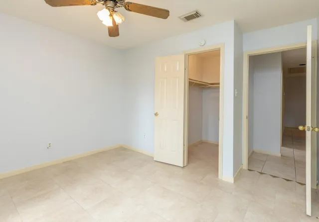 an empty room with chandelier fan