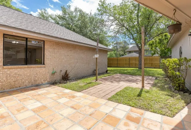 a backyard of a house with plants and large trees