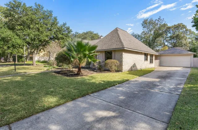 a view of a house with backyard and a tree