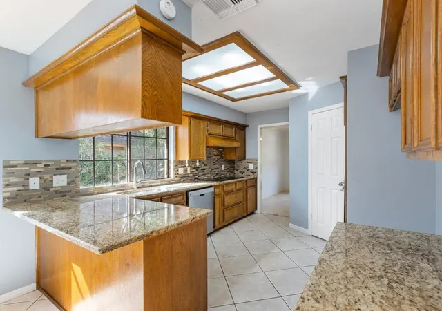 a kitchen with stainless steel appliances granite countertop a sink and a refrigerator