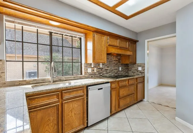 a kitchen with granite countertop sink and cabinets