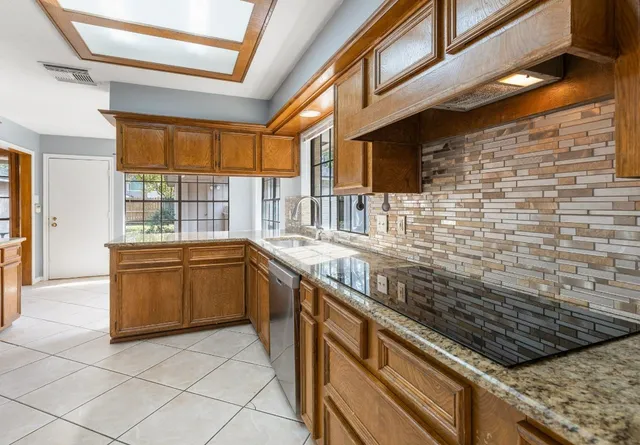 a kitchen with stainless steel appliances granite countertop a stove and a sink
