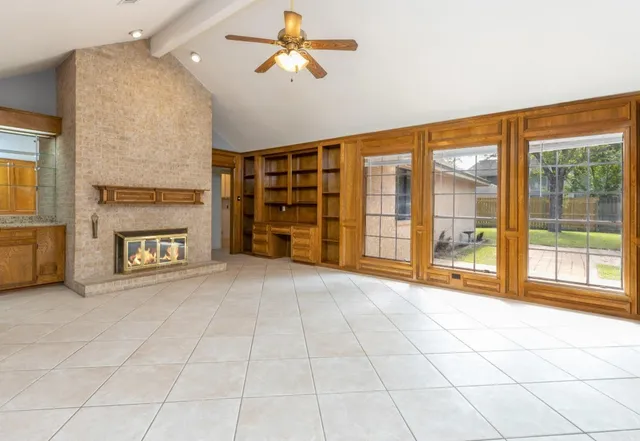 a view of an empty room with a fireplace and a window