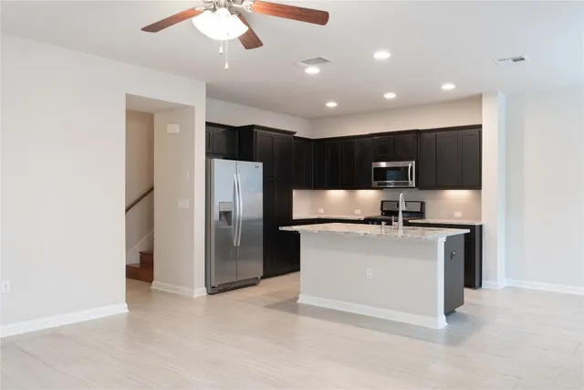 a kitchen with a sink refrigerator and cabinets