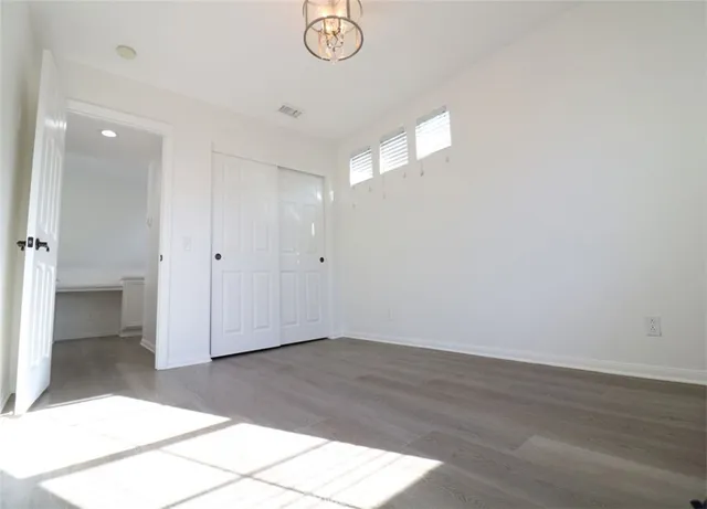 an empty room with wooden floor and window