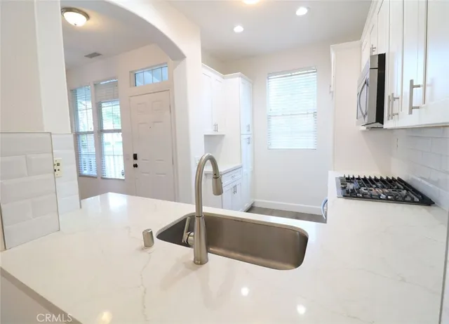 a kitchen with a sink a counter top space and cabinets