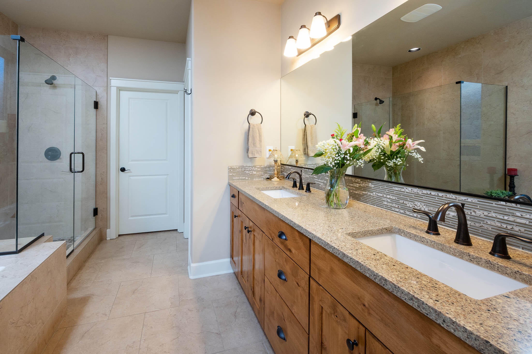 61129 Manhae Loop Bend, OR 97702 - Photo 12 of 44 Primary suite is spacious with both a tiled shower having pebble tile floor, large soaking tub has tile surround and matching tile flooring. Double undermount porcelain sinks, water closet, and spacious walk-in-closet.