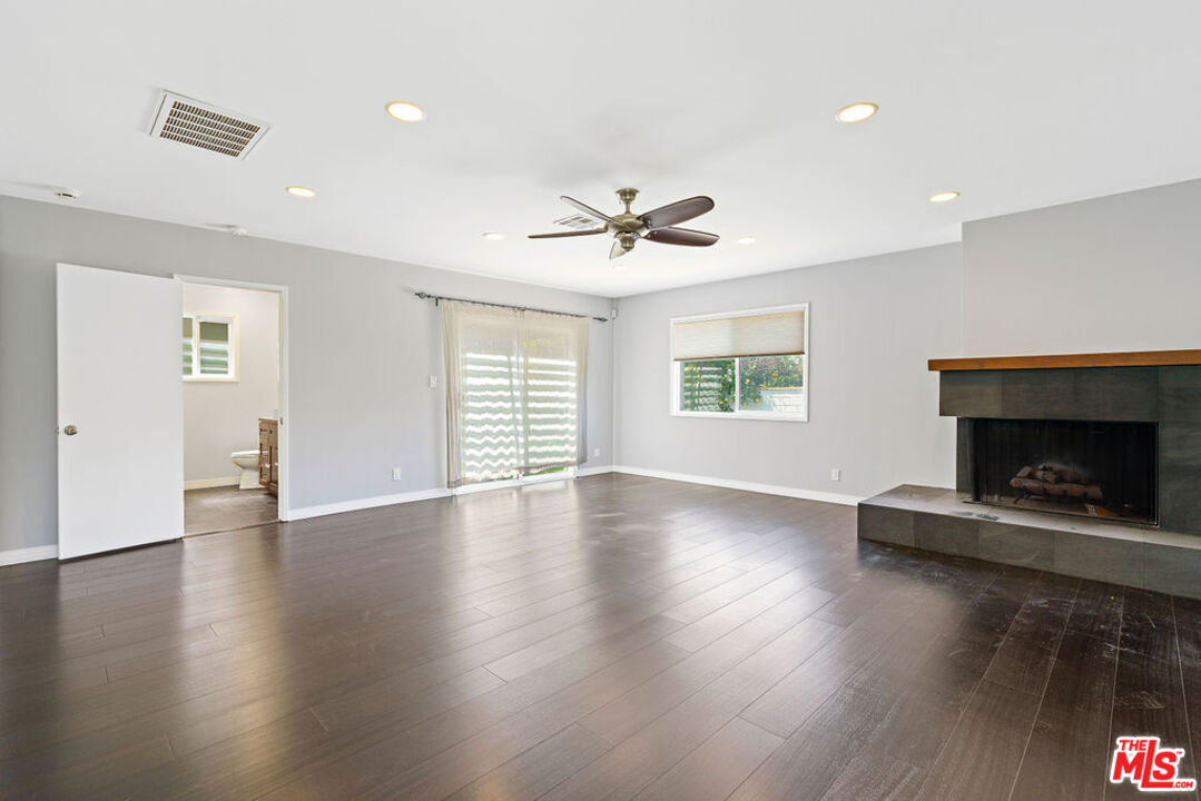 5343 Blanco Way Culver City, CA 90230 - Photo 16 of 30 an empty room with windows a fireplace and wooden floor