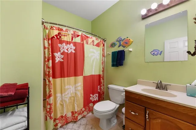 a bathroom with a sink mirror vanity and toilet