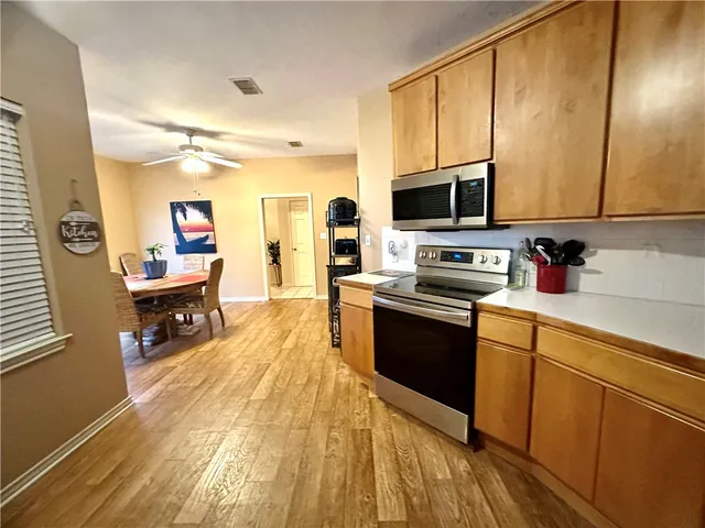 a kitchen with a sink a counter top space stainless steel appliances and a window