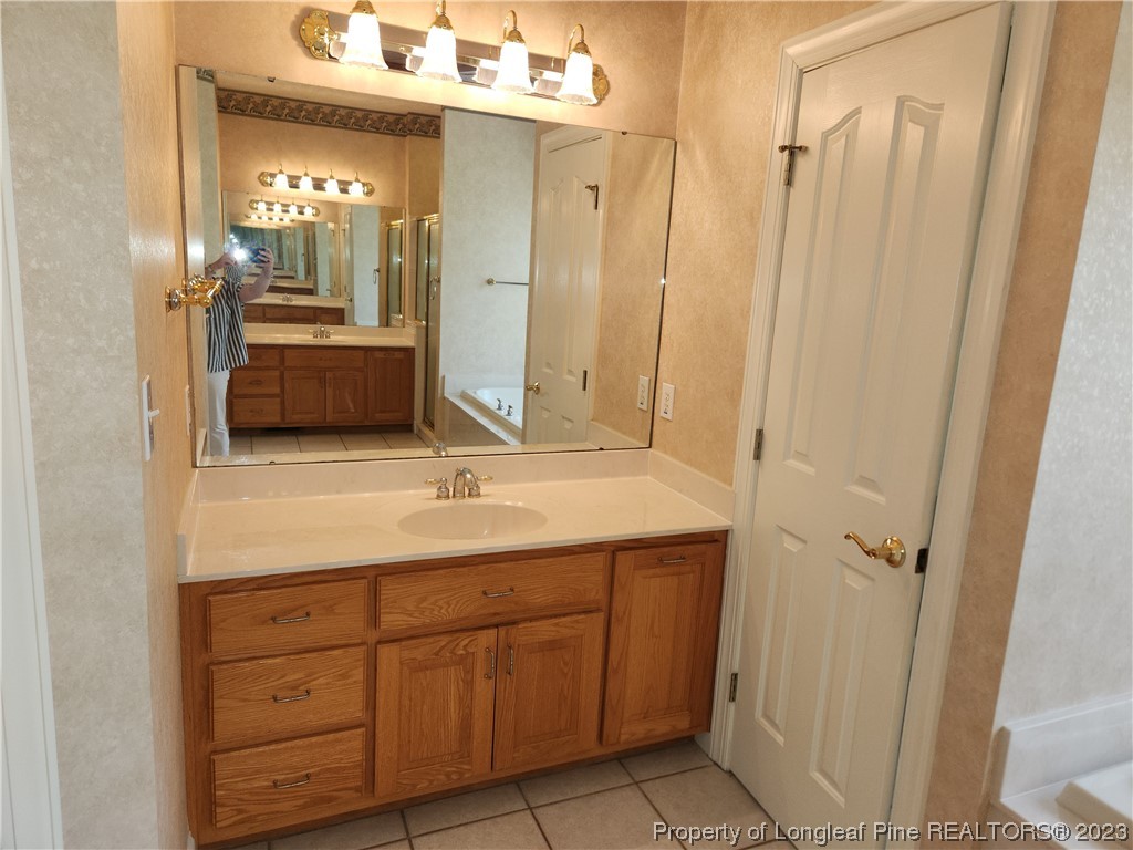 2730 Chimney Point Linden, NC 28356 - Photo 11 of 30 a bathroom with a granite countertop sink and a mirror