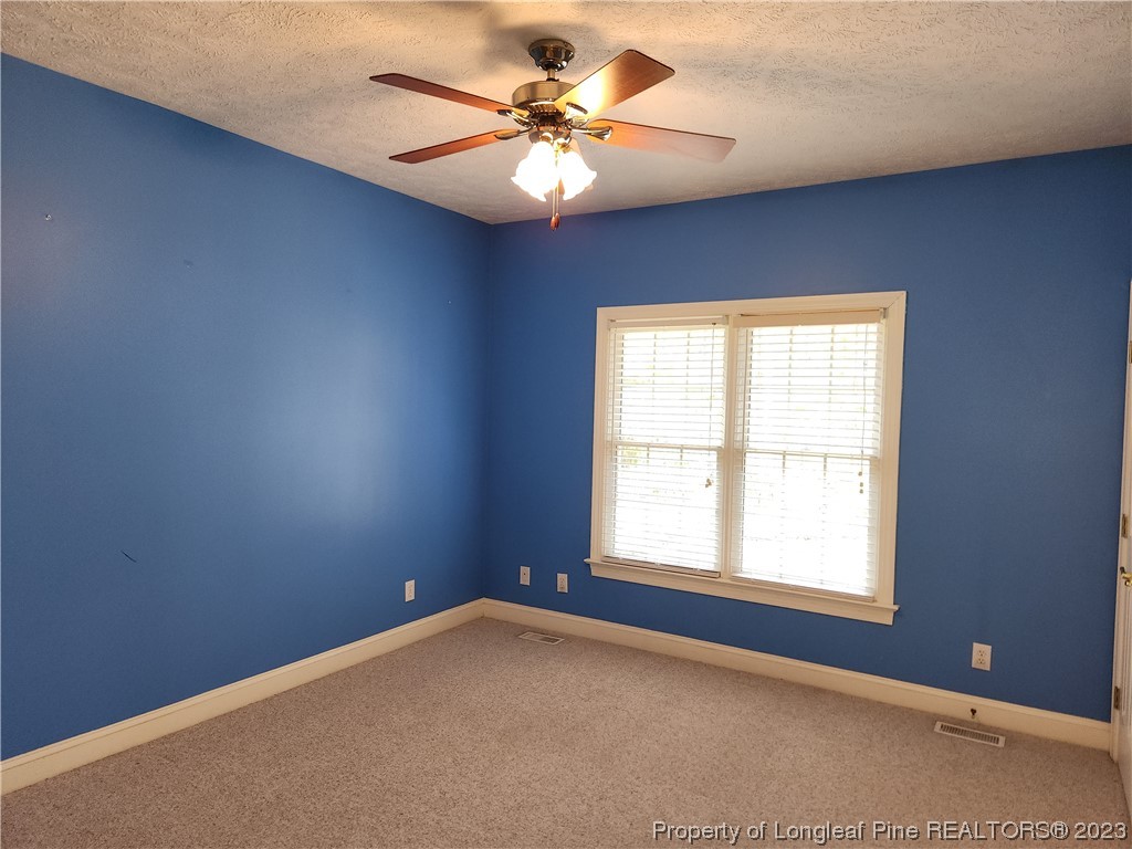 2730 Chimney Point Linden, NC 28356 - Photo 15 of 30 an empty room with windows and chandelier fan