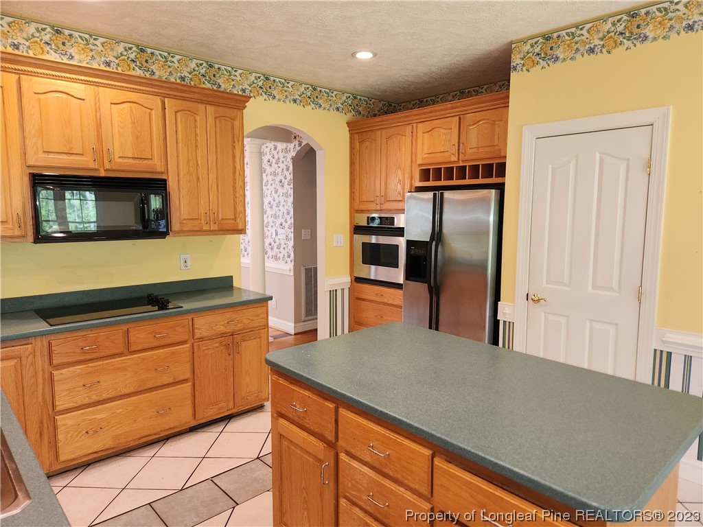 2730 Chimney Point Linden, NC 28356 - Photo 7 of 30 a kitchen with granite countertop a refrigerator and a stove top oven