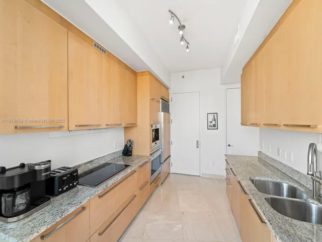 a kitchen with stainless steel appliances granite countertop a sink stove and cabinets