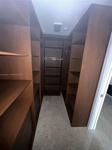 a view of walk in closet with empty racks