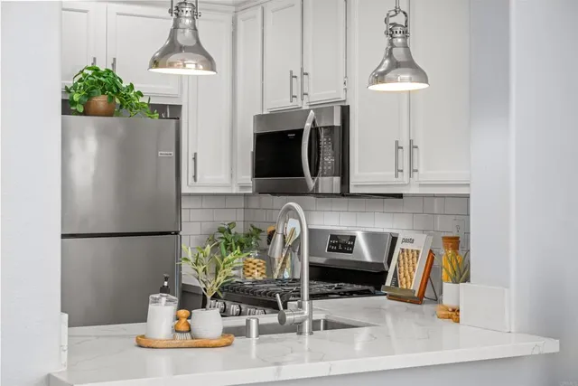 a kitchen with granite countertop a sink a stove and cabinets