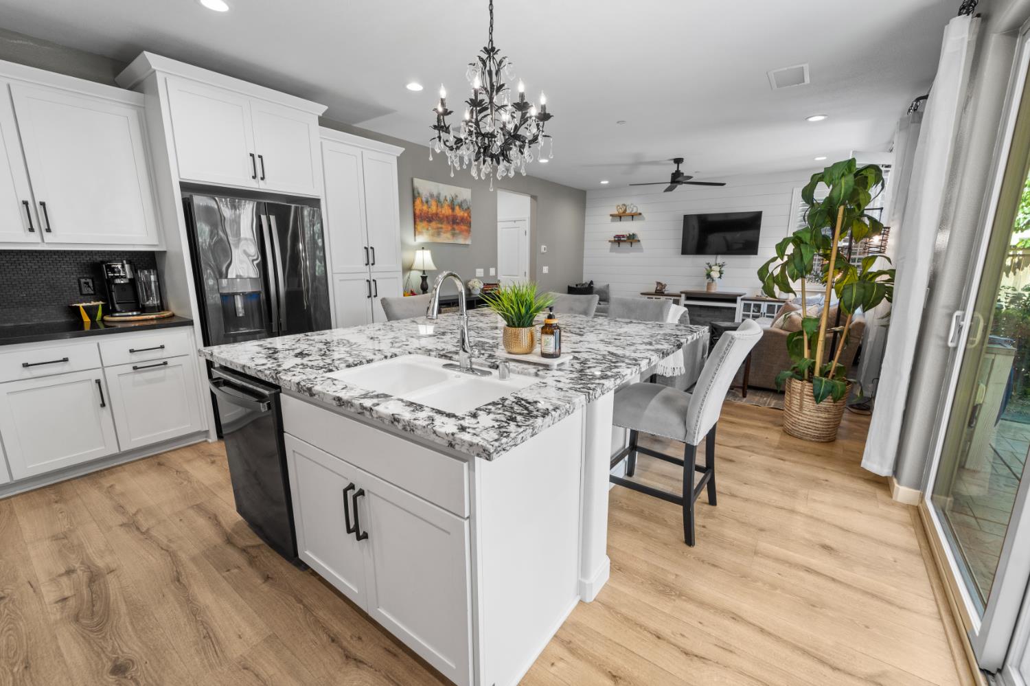 4301 San Miguel Road Madera, CA 93636 - Photo 21 of 60 a kitchen with stainless steel appliances kitchen island granite countertop a refrigerator a stove a sink dishwasher and white cabinets with wooden floor